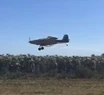 Un avión fumigando en un campo cercano al barrio Los Acantilados.